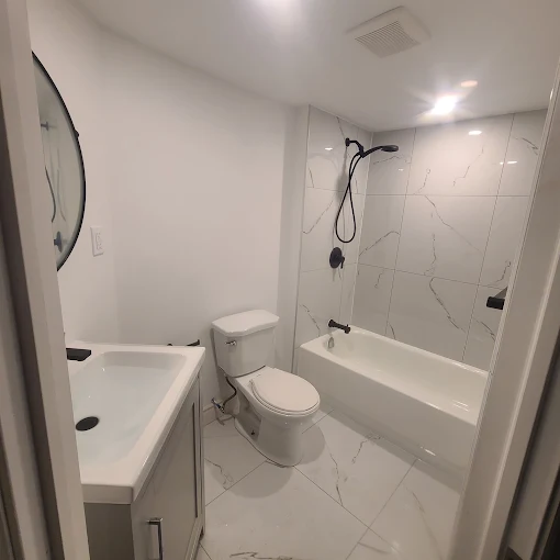 Finished bathroom renovation with marble-look tile, new tub and vanity