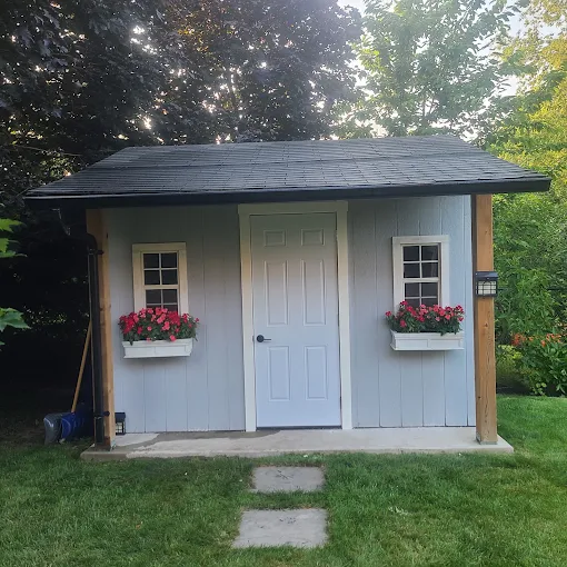 Custom backyard shed with window boxes and shingled roof