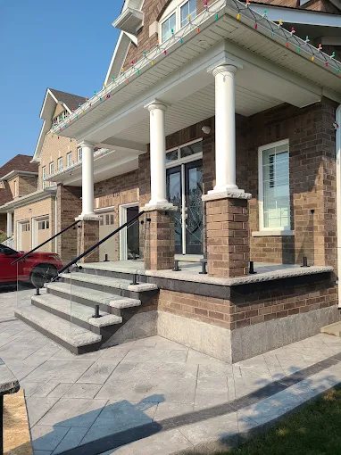 Front porch with stone steps, columns and glass railings in Oshawa